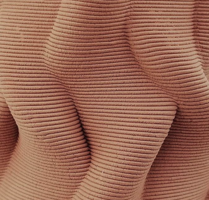 Close-up of a 3D-printed clay surface showing warm terracotta layers and flowing wave texture