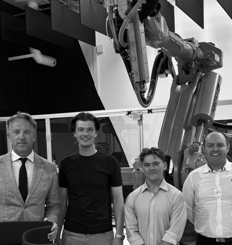 The Zerolab team standing beside the large format robotic printing arm